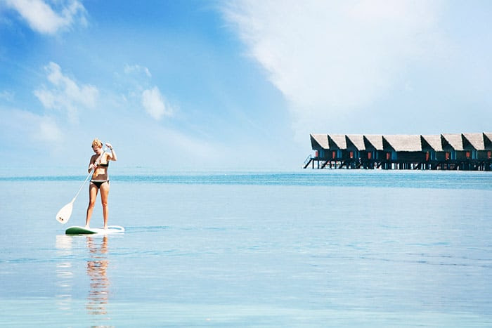 girl standing on paddle board maldives adaaran select hudhuranfushi maldives