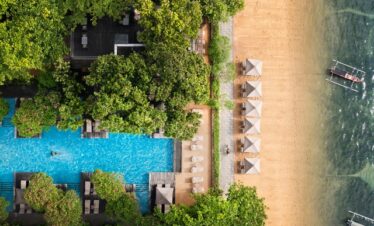 Aerial view of Maya Sanur Resort showing pool beach and lush greenery
