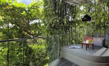 Balcony at Maya Sanur Resort with lush garden views and private lounge area