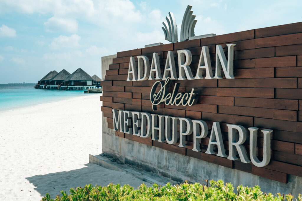 Adaaran Meedhupparu resort entrance sign on sandy beach