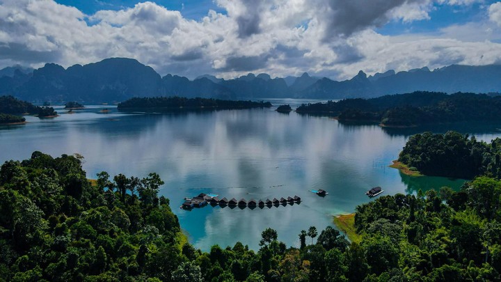 Aerial view of 500Rai Floating Resort in a serene lake setting with mountain backdrops