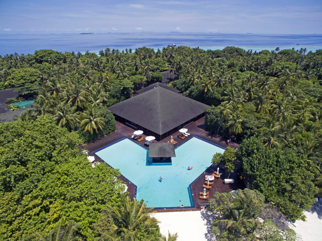 Aerial view of Adaaran Meedhupparu resort surrounded by lush greenery and ocean
