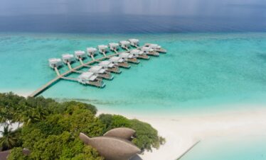 Aerial view of Dhigali overwater villas and turquoise lagoon