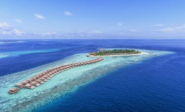 Aerial view of Hurawalhi Island Resort with overwater villas extending into the ocean