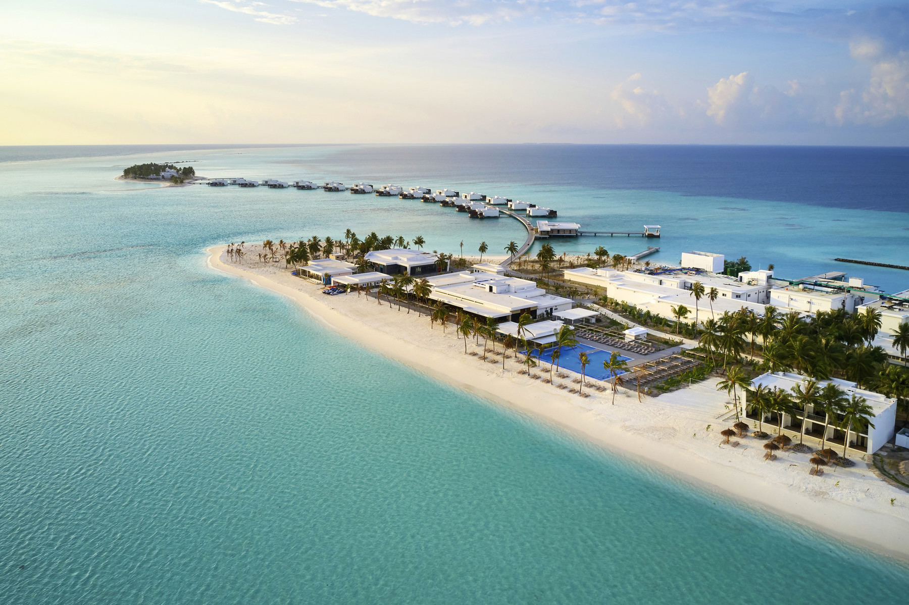 Aerial view of Riu Atoll resort with overwater villas and sandy beach