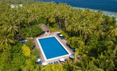 Aerial view of Vilamendhoos main pool surrounded by palm trees and tropical foliage