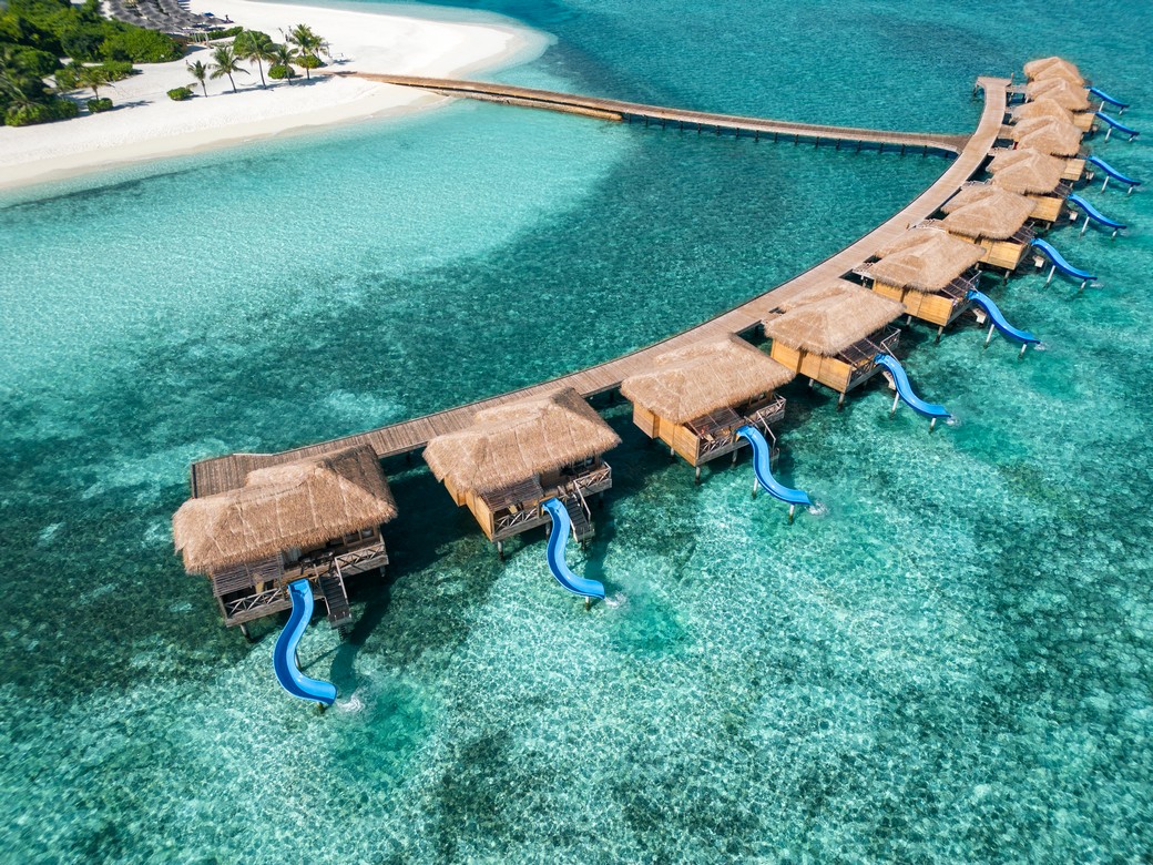 Aerial view of You and Me by Cocoon overwater villas with slides into the ocean