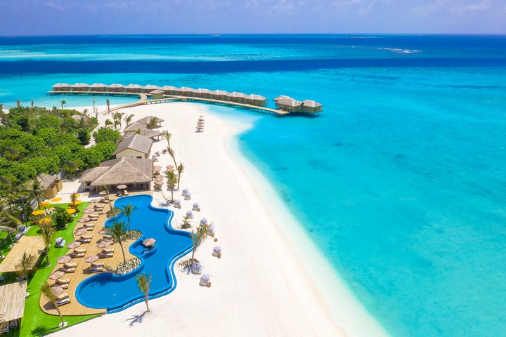 Aerial view of You and Me by Cocoon resort with turquoise water and beach villas
