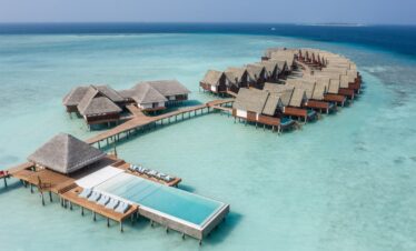 Aerial view of the infinity pool at Heritance Aarah with wooden loungers on the deck