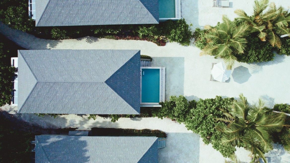 Aerial view of villas at Jawakara Dheru Island with private pools and lush surroundings
