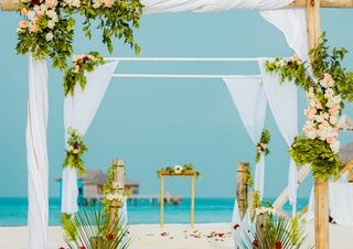 Beach wedding setup at You and Me by Cocoon resort with floral archway