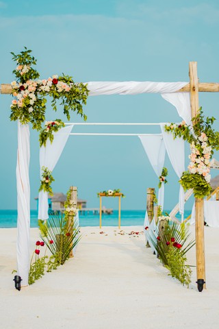 Beach wedding setup at You and Me by Cocoon resort with floral archway