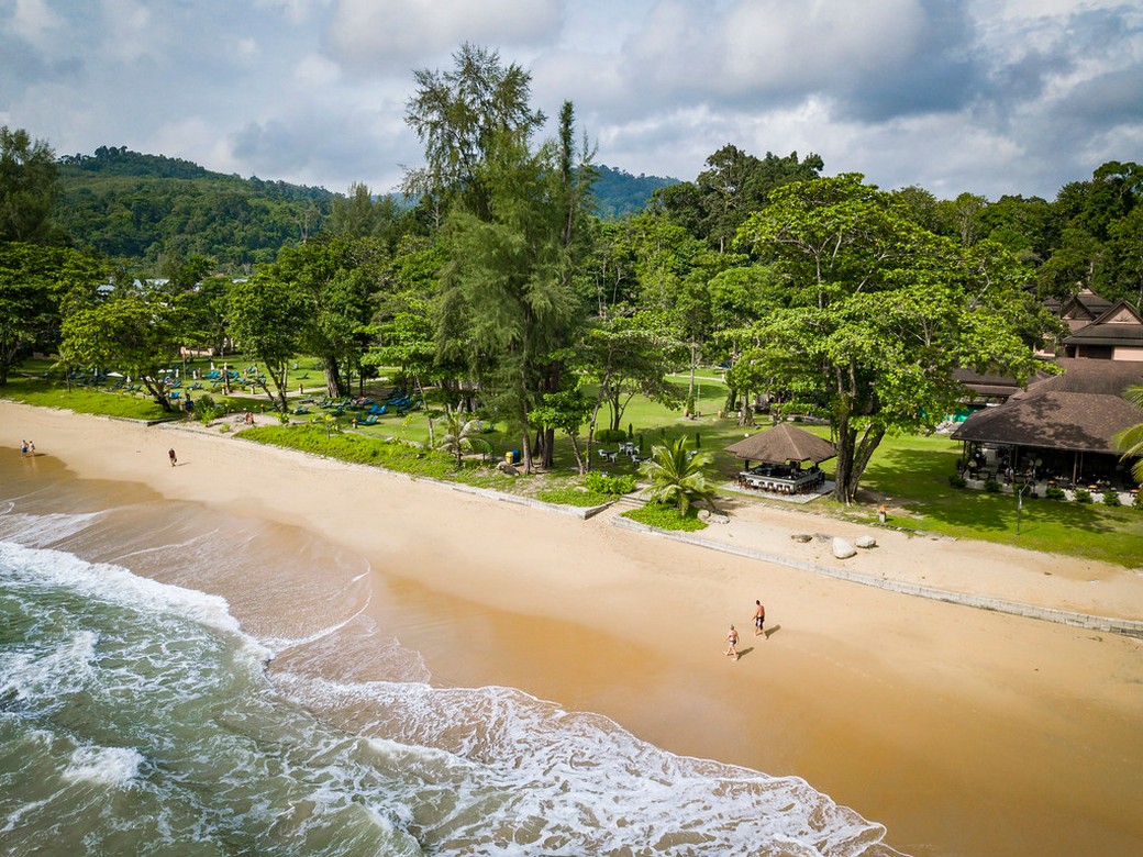 Beachfront view at Khao Lak Merlin with ocean waves and green landscape