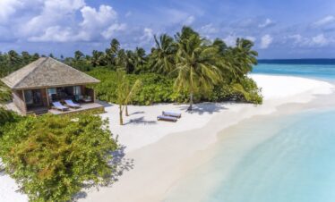 Beachfront villa surrounded by lush vegetation at Hurawalhi Island Resort