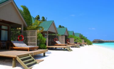 Beachfront villas at Meeru Island Resort with private decks overlooking the white sandy beach and turquoise waters