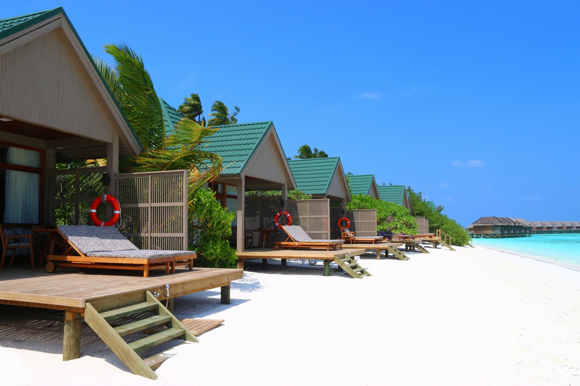 Beachfront villas at Meeru Island Resort with private decks overlooking the white sandy beach and turquoise waters