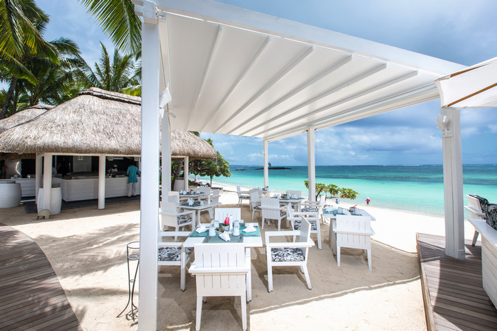 Beachside dining area at Constance Belle Mare Plage with white furniture