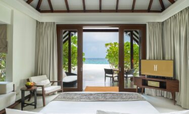 Bedroom at Heritance Aarah with ocean views through large sliding doors