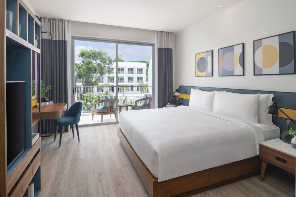 Bright and airy bedroom at Avani Chaweng Samui with a view of the resort’s garden and modern furnishings