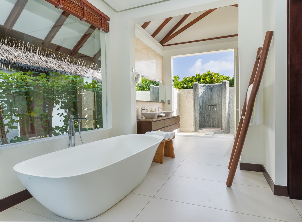 Bright bathroom at Heritance Aarah with a freestanding tub and outdoor shower