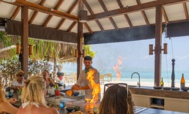 Chef cooking with fire at You and Me by Cocoon resort restaurant by the beach