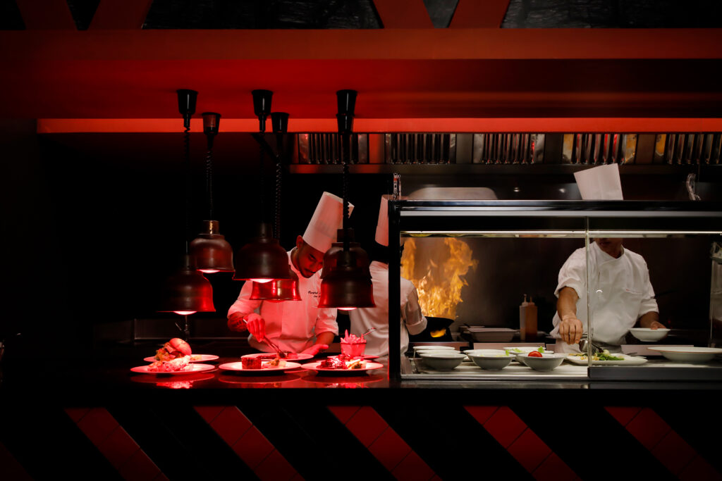 Chefs preparing gourmet meals in a vibrant kitchen at Riu Atoll