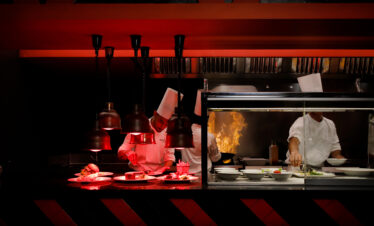 Chefs preparing gourmet meals in a vibrant kitchen at Riu Atoll
