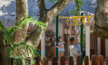 Children playing at the Adaaran Meedhupparu playground with a staff member