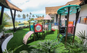 Colorful childrens playground at The Vijitt Resort with a backdrop of palm trees and ocean