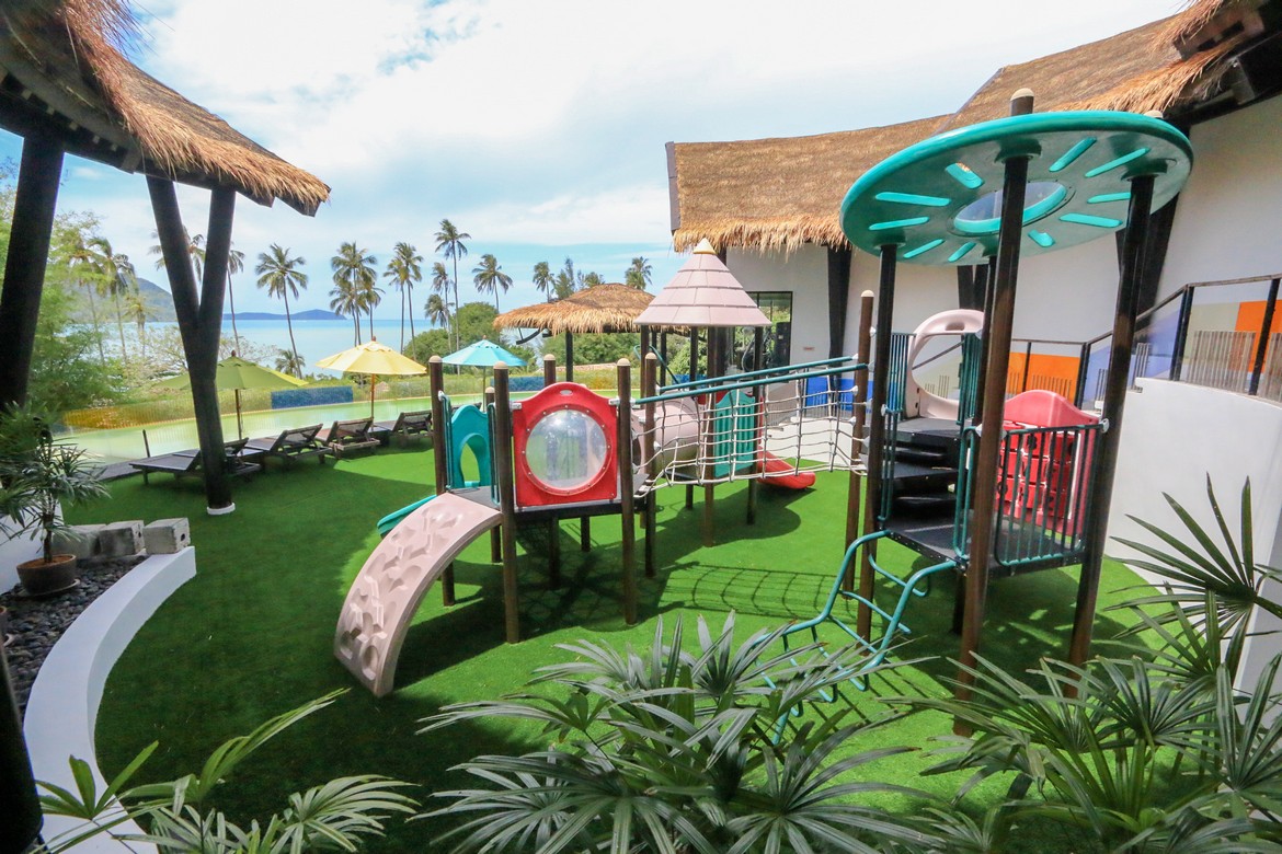 Colorful childrens playground at The Vijitt Resort with a backdrop of palm trees and ocean