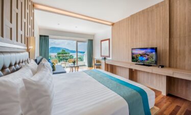 Comfortable bedroom with a scenic ocean view at Diamond Cliff Resort