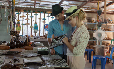 Couple browsing handcrafted souvenirs at a local market near Meeru Island Resort surrounded by colorful traditional crafts