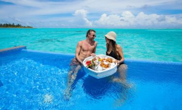 Couple enjoying a floating breakfast in a pool at Riu Palace