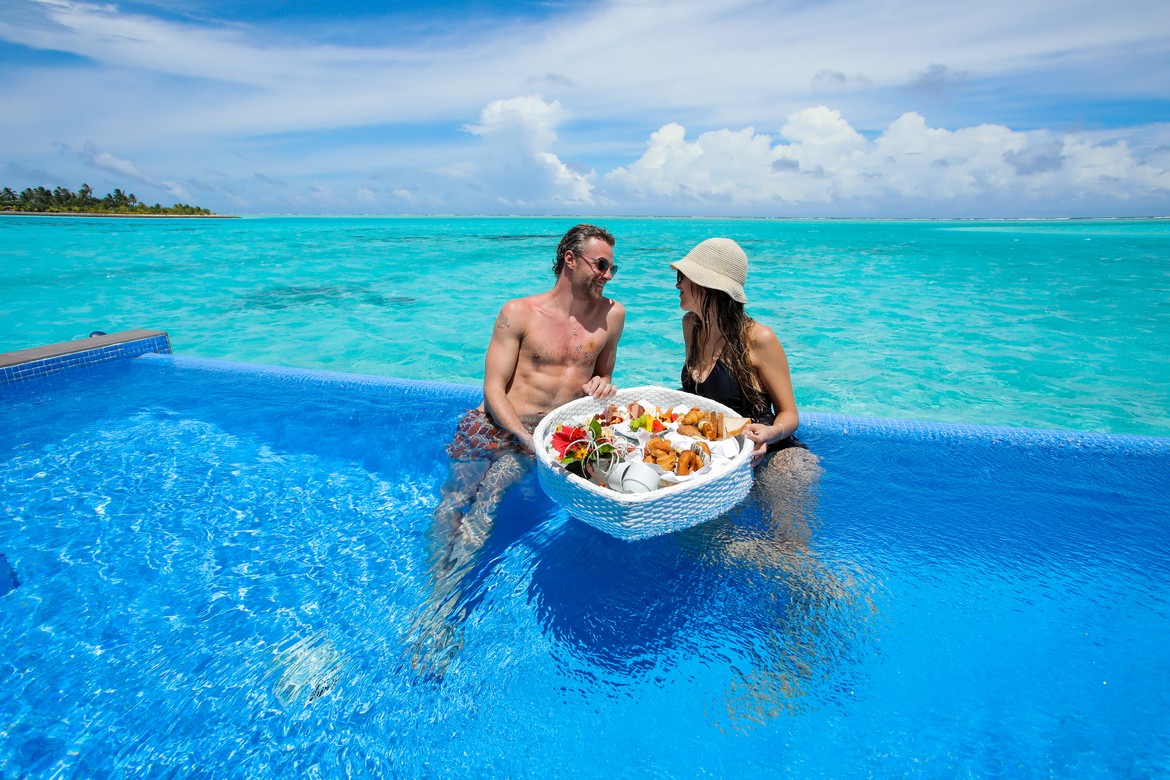 Couple enjoying a floating breakfast in a pool at Riu Palace
