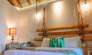 Cozy bedroom with natural wood decor at Constance Moofushi