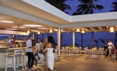 Evening social gathering at the outdoor bar area of Riu Palace