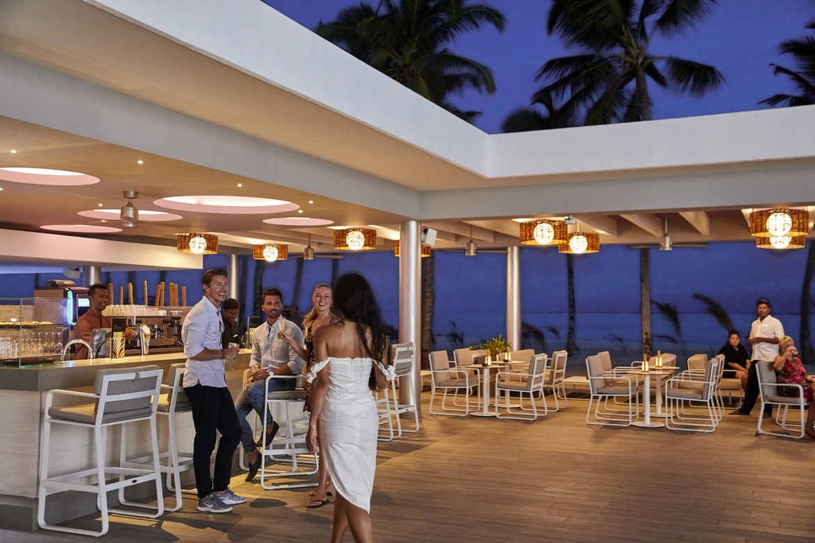 Evening social gathering at the outdoor bar area of Riu Palace