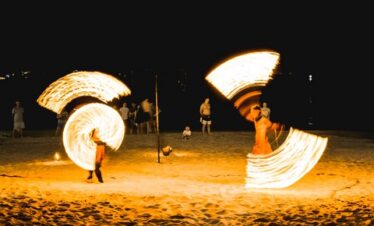 Fire dancers performing on the beach at Diamond Cliff Resort during a night event