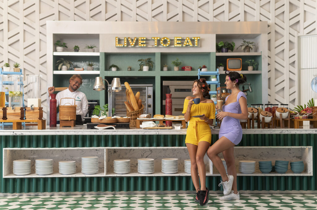 Guests enjoying breakfast at Avani Chaweng Samui restaurant with vibrant decor and live to eat sign