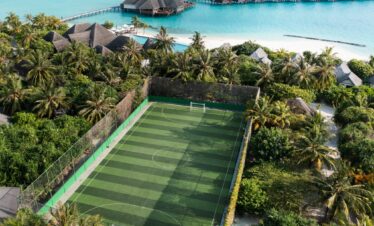 Heritance Aarah aerial view showing a lush green football field near overwater villas