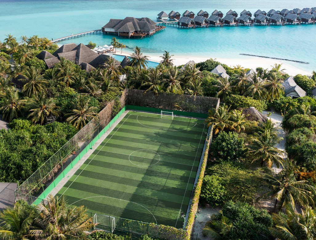 Heritance Aarah aerial view showing a lush green football field near overwater villas