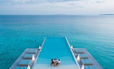 Heritance Aarah infinity pool with romantic dinner setup at the pool edge