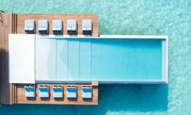 Heritance Aarah luxurious overwater villas connected by wooden walkways above clear blue ocean