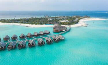 Heritance Aarah overwater villas extending into turquoise waters connected by a wooden walkway