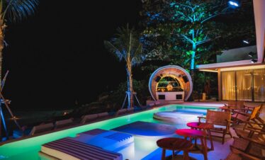 Illuminated poolside lounge at Diamond Cliff Resort with cozy seating and vibrant lighting