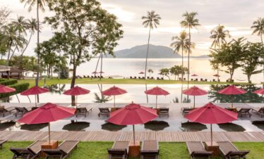 Infinity pool with red umbrellas overlooking the ocean at The Vijitt Resort