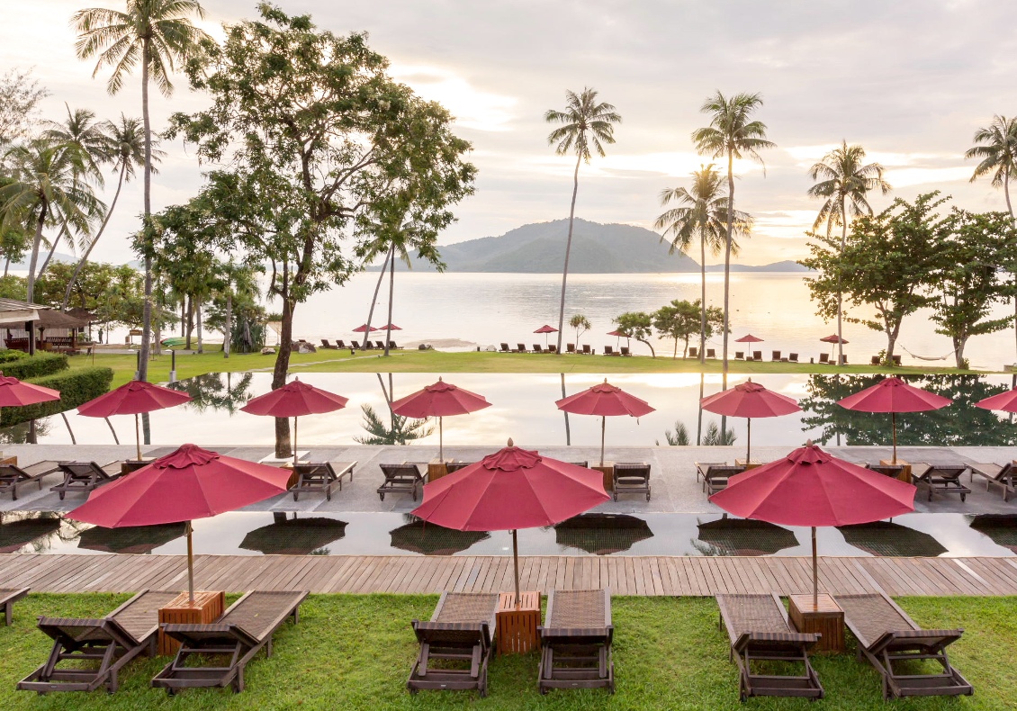 Infinity pool with red umbrellas overlooking the ocean at The Vijitt Resort