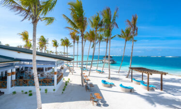 Joy Island beachfront dining area with palm trees
