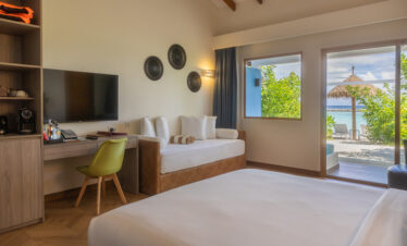 Joy Island resort room interior with cozy bed