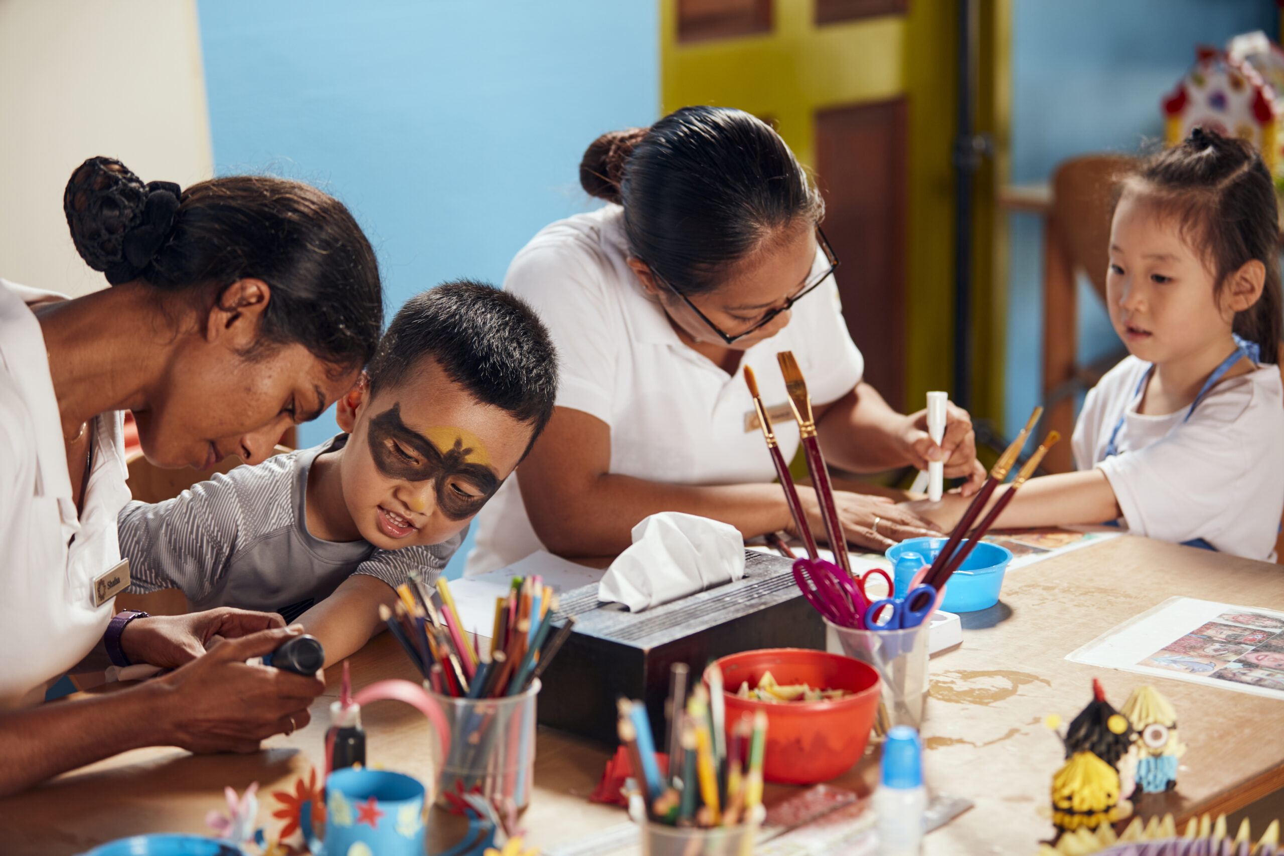 Kids club activity at Sun Siyam Iru Fushi with children enjoying arts and crafts with attentive staff